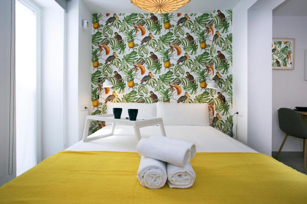 een slaapkamer met een bed met tropisch behang bij MONKÓ - LEMON & TROPYCAL APARTMENT o in Torremolinos