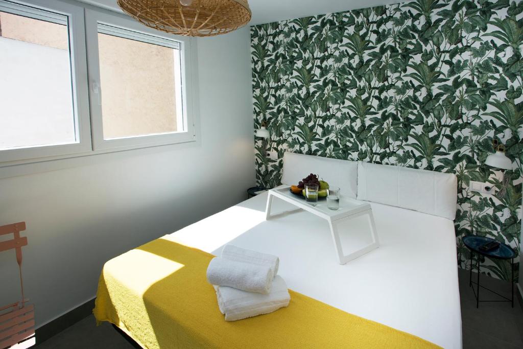 - une chambre dotée d'un lit avec une couverture jaune et blanche dans l'établissement MONKÓ - BANANA & TROPYCAL APARTMENT o, à Torremolinos