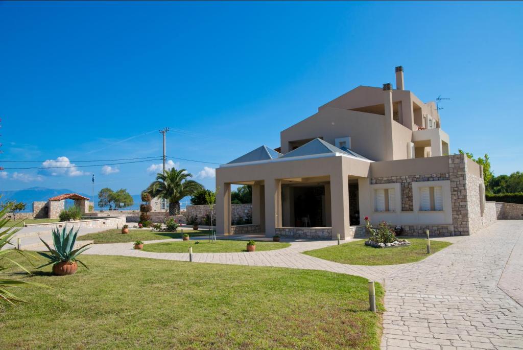 a large white house with a driveway at Villa Eleni in Drosia