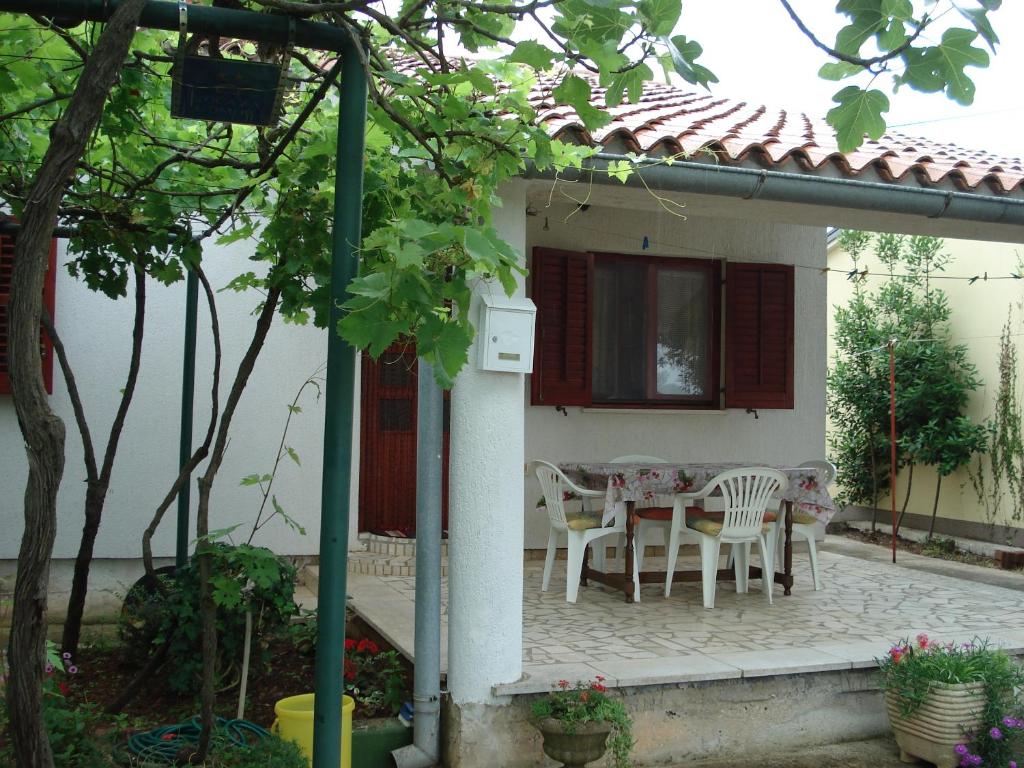 un patio con mesa y sillas en una casa en Medel, en Medulin