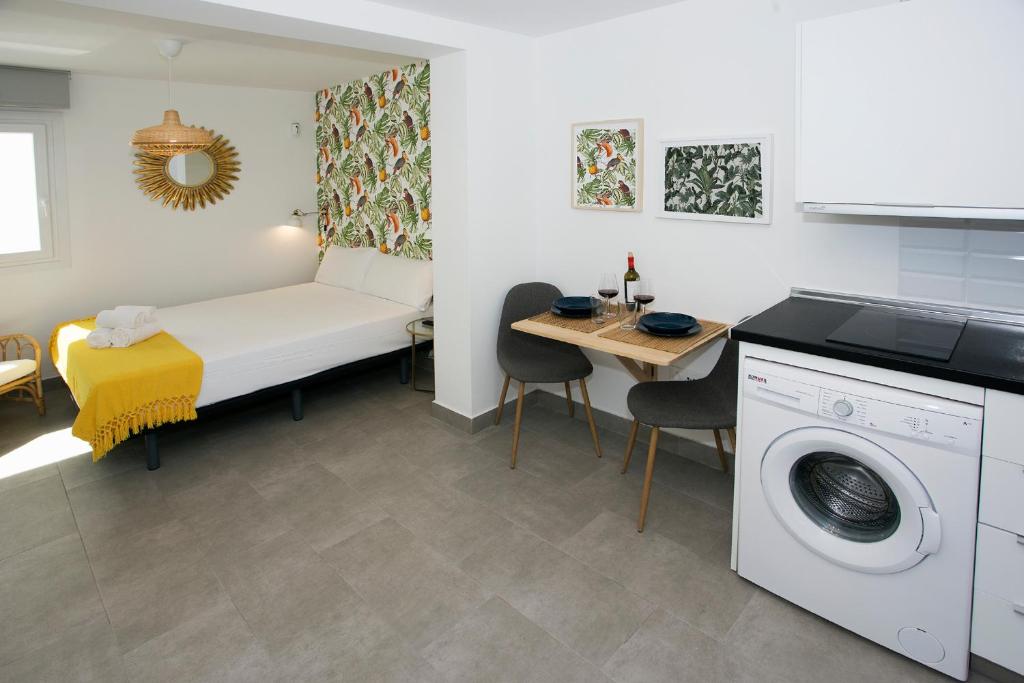 Habitación con cama, mesa y lavadora. en MONKÓ - KIWI & TROPYCAL APARTMENT o en Torremolinos