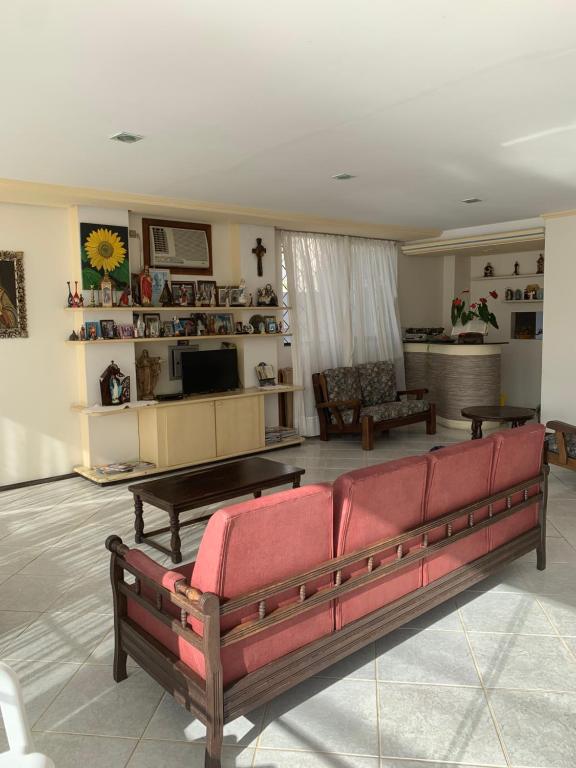 uma sala de estar com um sofá e uma televisão em Hotel Luz do Sol em Balneário Camboriú