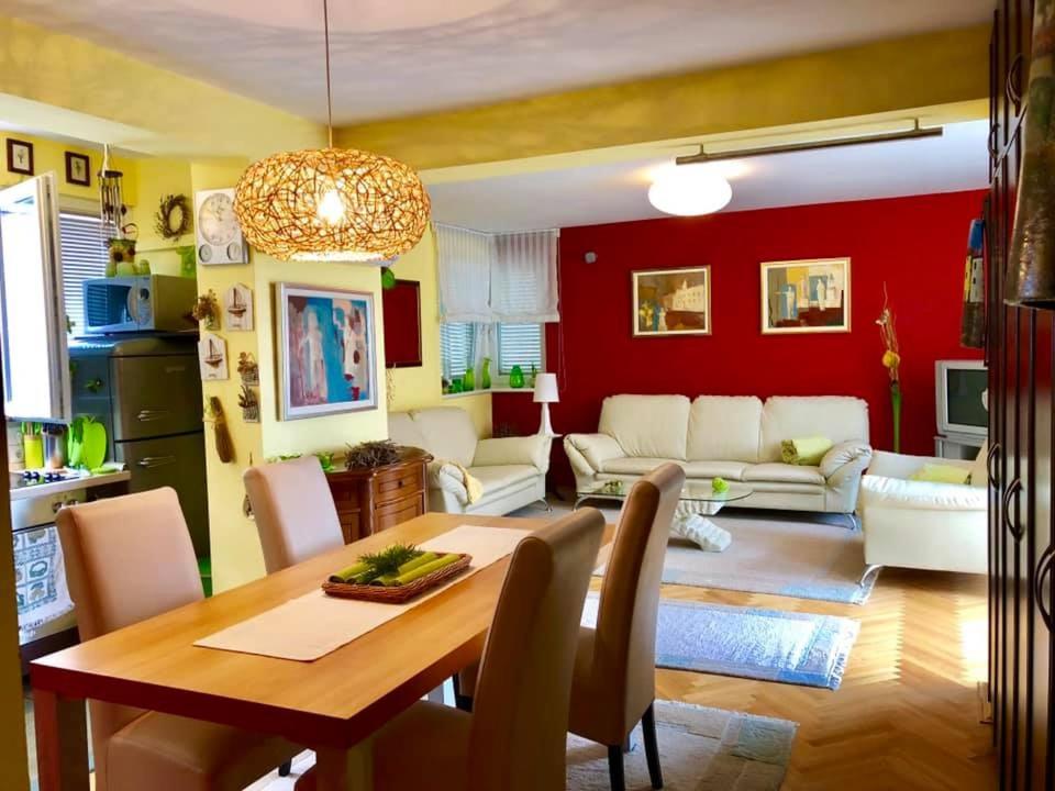 comedor y sala de estar con mesa y sillas en Luxury Apartman Porat, en Porat