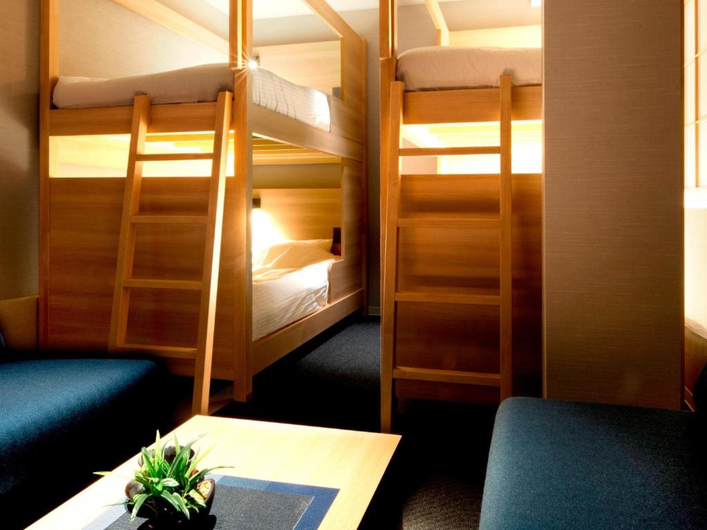 Zimmer mit 2 Etagenbetten, einem Tisch und einem Schreibtisch in der Unterkunft ALPHABED INN Takamatsuekimae 303 / Vacation STAY 36564 in Takamatsu