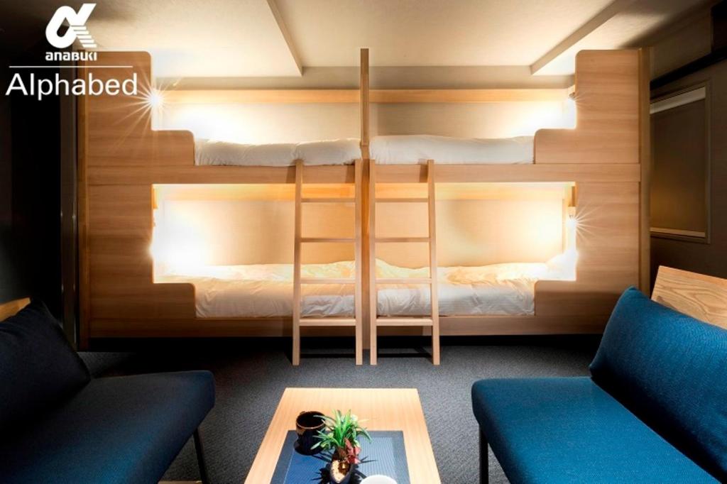 a room with two bunk beds and a coffee table at ALPHABED INN Takamatsuekimae 301 / Vacation STAY 36560 in Takamatsu