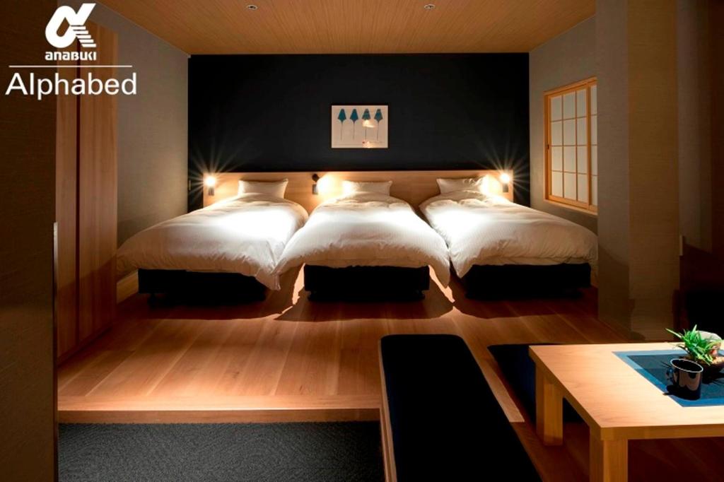 a bedroom with two beds and a table at ALPHABED INN Takamatsuekimae 202 / Vacation STAY 36555 in Takamatsu