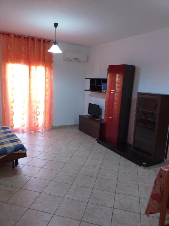 a living room with a red cabinet and a television at Appartamento Vibo Valentia Marina Vicino il mare in Vibo Valentia Marina