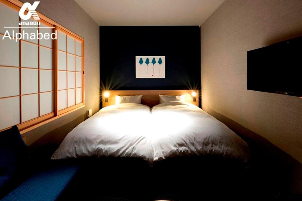 Un dormitorio con una cama blanca con luces. en ALPHABED INN Takamatsuekimae 101 / Vacation STAY 15549, en Takamatsu