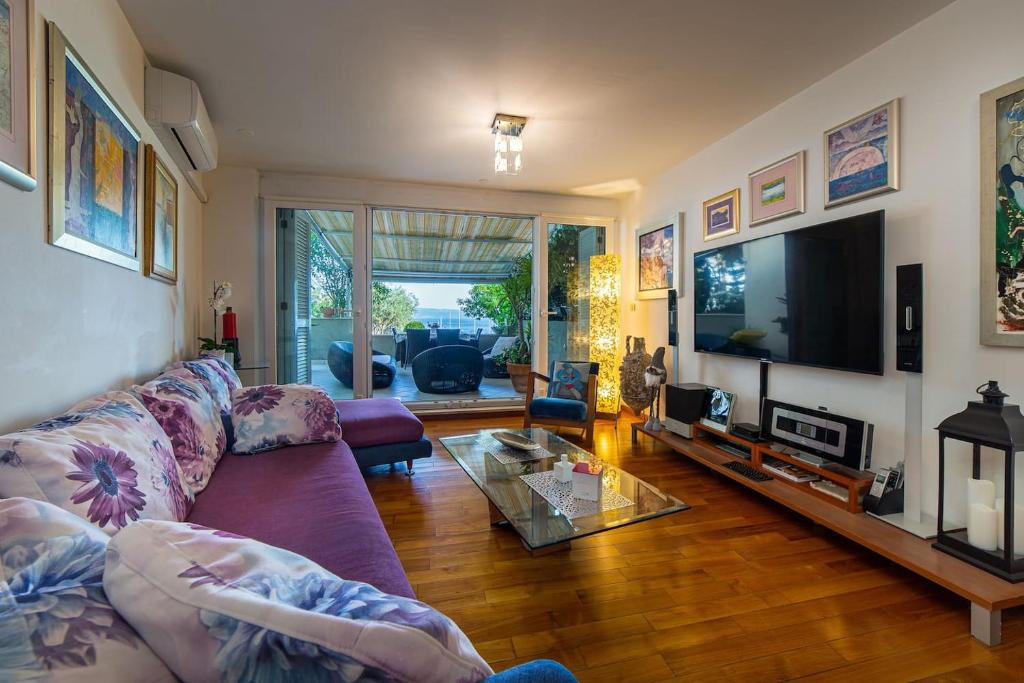 sala de estar con sofá púrpura y TV en Zen Luxury Apartment, en Split