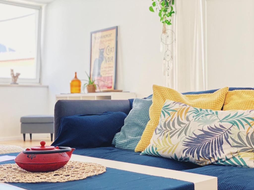 a blue couch with colorful pillows in a living room at Modern Beautiful House in Odeceixe