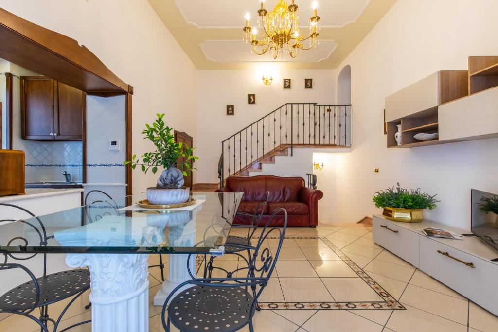 Medina Central في نابولي: مطبخ وغرفة معيشة مع طاولة وكراسي زجاجية