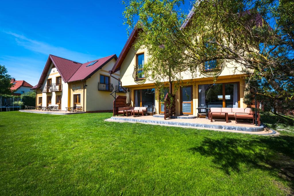 a house with a yard with green grass at Domki-Willa Horyzont in Dębki