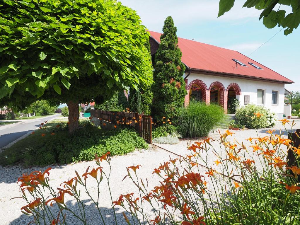 een huis met een rood dak en een boom bij Hoffman Apartment in Balatonszárszó