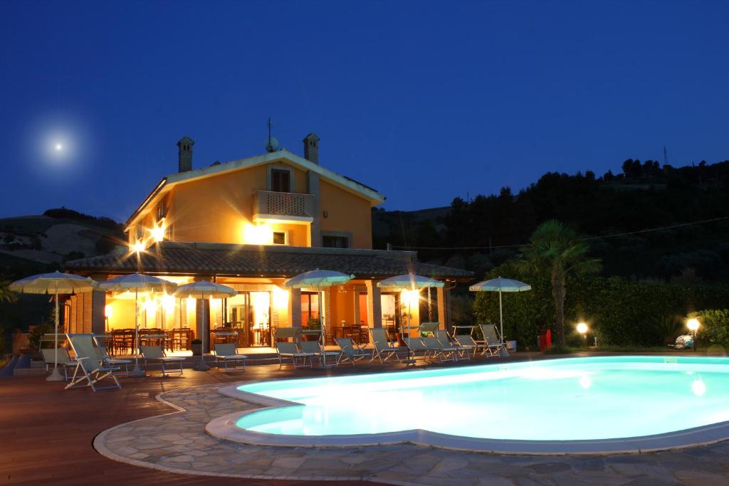 a swimming pool in front of a house at night at Country House La Foggetta in Pineto