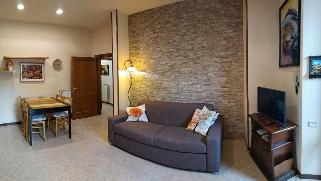ein Wohnzimmer mit Sofa und Ziegelwand in der Unterkunft Casa Taiuti in San Piero a Sieve