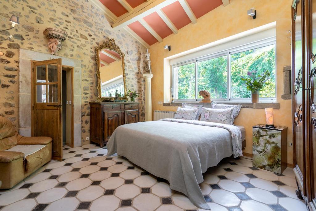 um quarto com uma cama e uma grande janela em La maison de Raphaël em Tournon-sur-Rhône