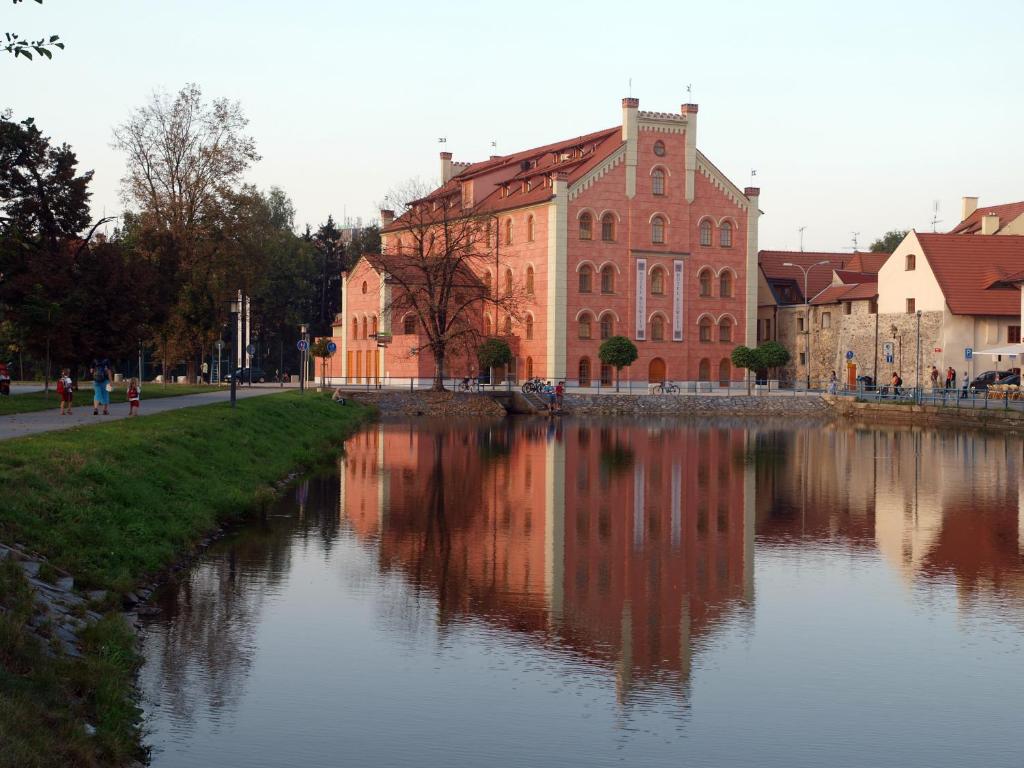 a building next to a river in front of a building at Hotel Budweis in České Budějovice