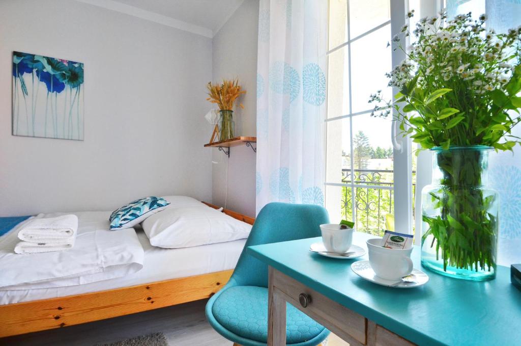een kleine kamer met een bed, een bureau en een raam bij Mari Vera in Mielno