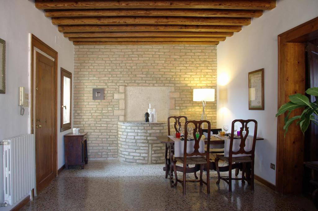 ein Esszimmer mit einem Tisch, Stühlen und einem Kamin in der Unterkunft Appartamenti San Luca in Venedig