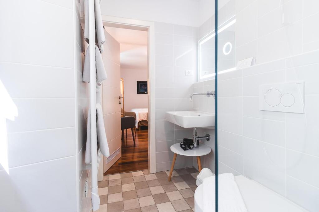 a bathroom with a toilet and a sink at Second Life in Piran - Hotel Zala Piran in Piran