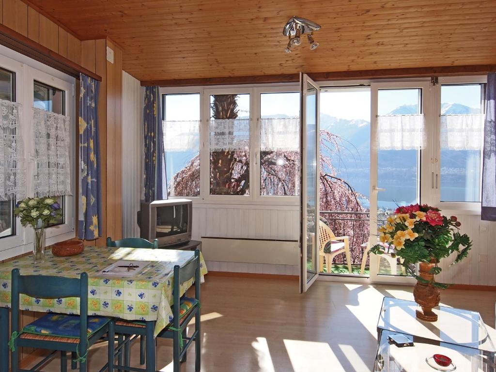 uma sala de estar com uma mesa e uma grande janela em Casa Sibylle bei Locarno em Locarno