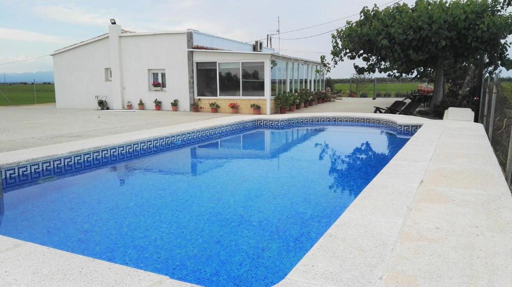 a swimming pool in front of a house at Mas Panoli in Deltebre