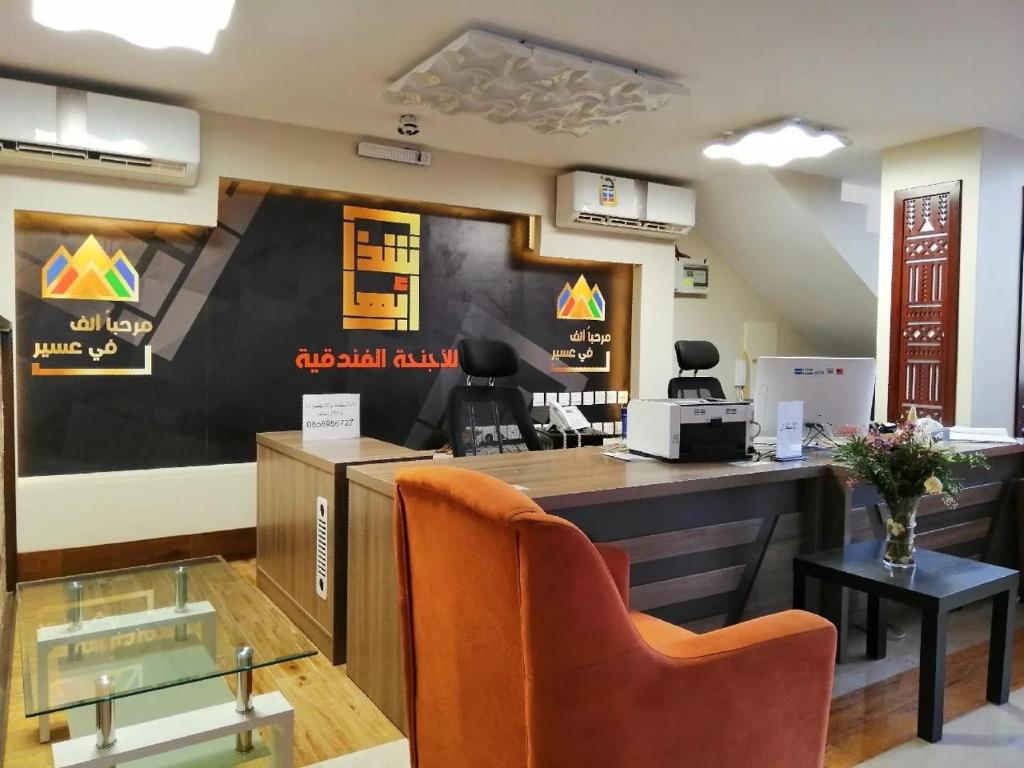 an office with a reception desk with avertisement for at Shatha Abha Furnished Units in Abha