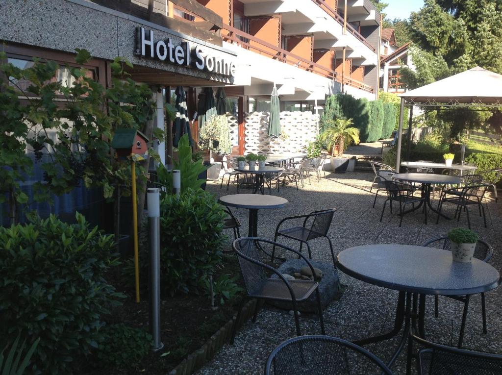 eine Außenterrasse mit Tischen und Stühlen sowie eine Suite im Hotel in der Unterkunft Hotel-Restaurant Sonne in Talheim