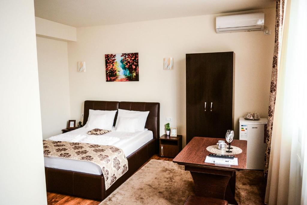 a hotel room with a bed and a table at Martin'Suite in Alba Iulia
