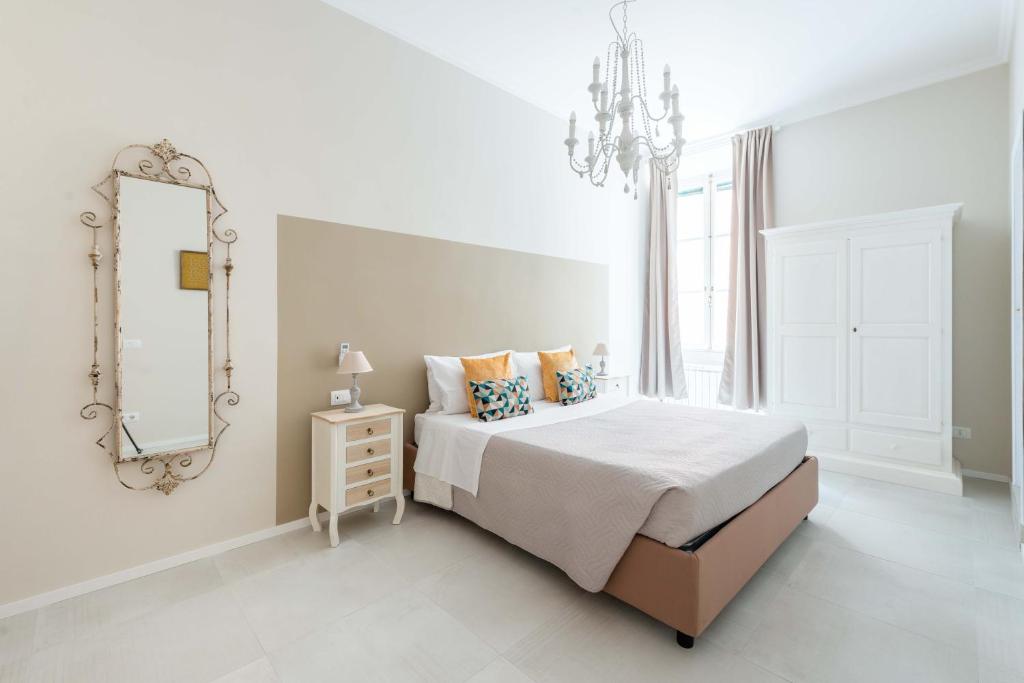 a white bedroom with a bed and a mirror at SuityRHome RioneMonti54 in Rome