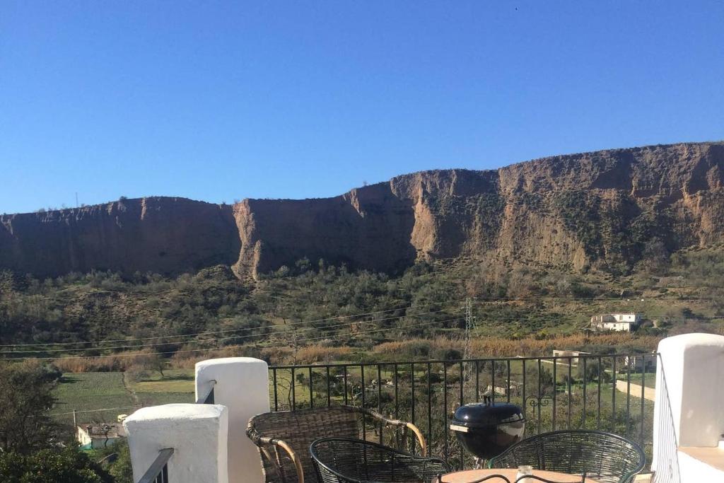 a table and chairs with a mountain in the background at Villa Ugijar in Ugíjar