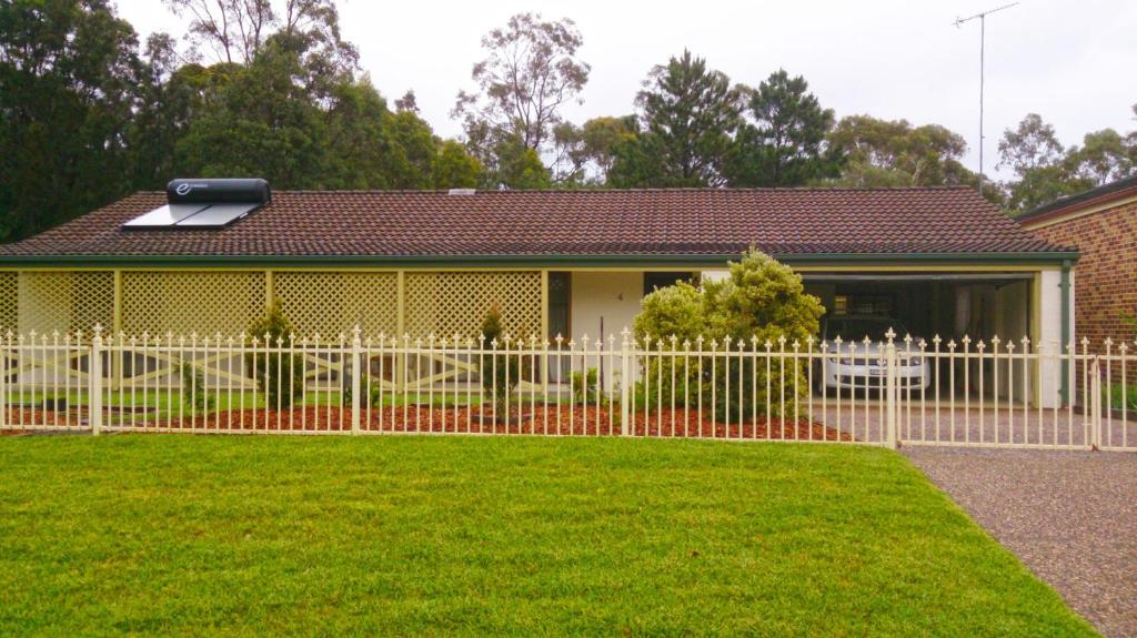 a white fence in front of a house at WARR4C - Home Away in Myola