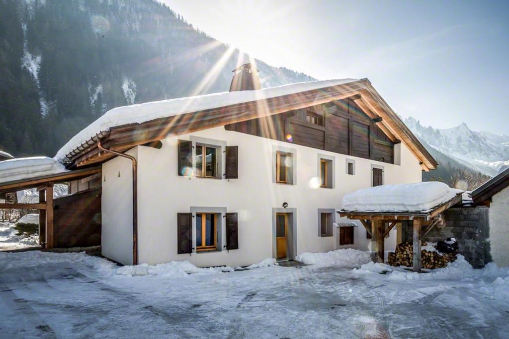 Ein Haus im Schnee mit Sonne in der Unterkunft Les Iles 1776 in Chamonix-Mont-Blanc