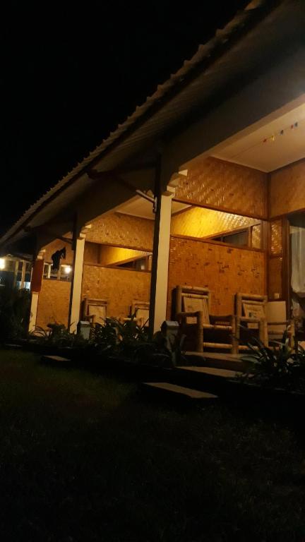 a building lit up at night with tables and chairs at Ila Homestay in Senaru