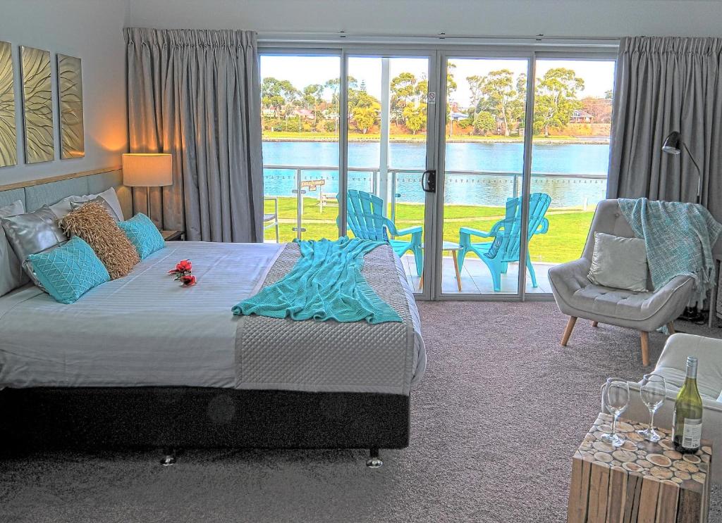 a bedroom with a bed and a view of the water at Ulverstone River Edge HolidayApartments in Ulverstone
