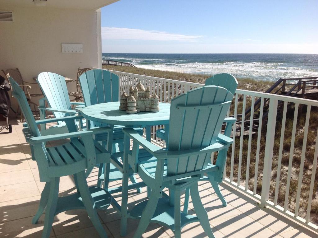 een tafel en stoelen op een balkon met uitzicht op de oceaan bij Sea Oats Condo Unit #202 in Navarre