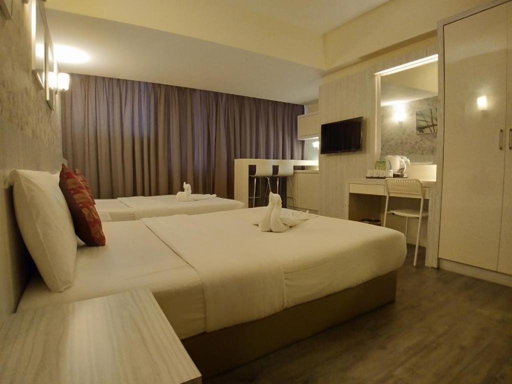 A twin room with two beds, a wall-mounted television, desk, and wardrobe.