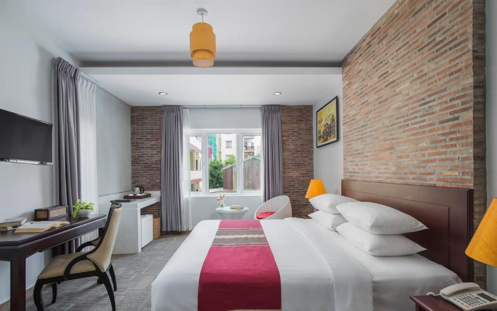 a hotel room with a bed and a brick wall at Sovanna Hotel in Phnom Penh