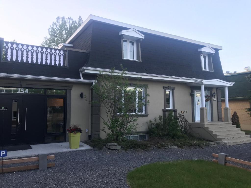 una casa blanca con techo negro en Le 154 Jacques-Cartier, en Gaspé