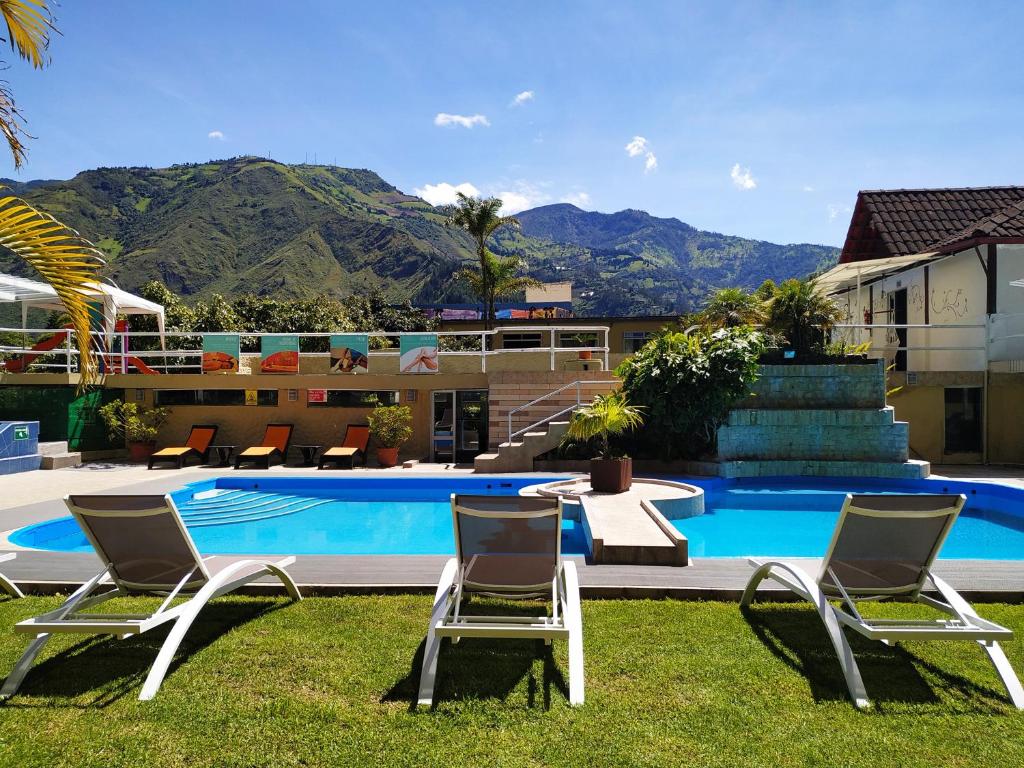 a group of chairs sitting next to a swimming pool at Monte Selva Spa Termal in Baños