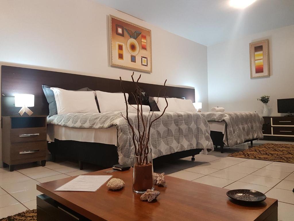 Un dormitorio con una cama y una mesa de madera con una mesa de madera. en B & A Suites Inn Hotel - Quarto Luxo Premium, en Anápolis