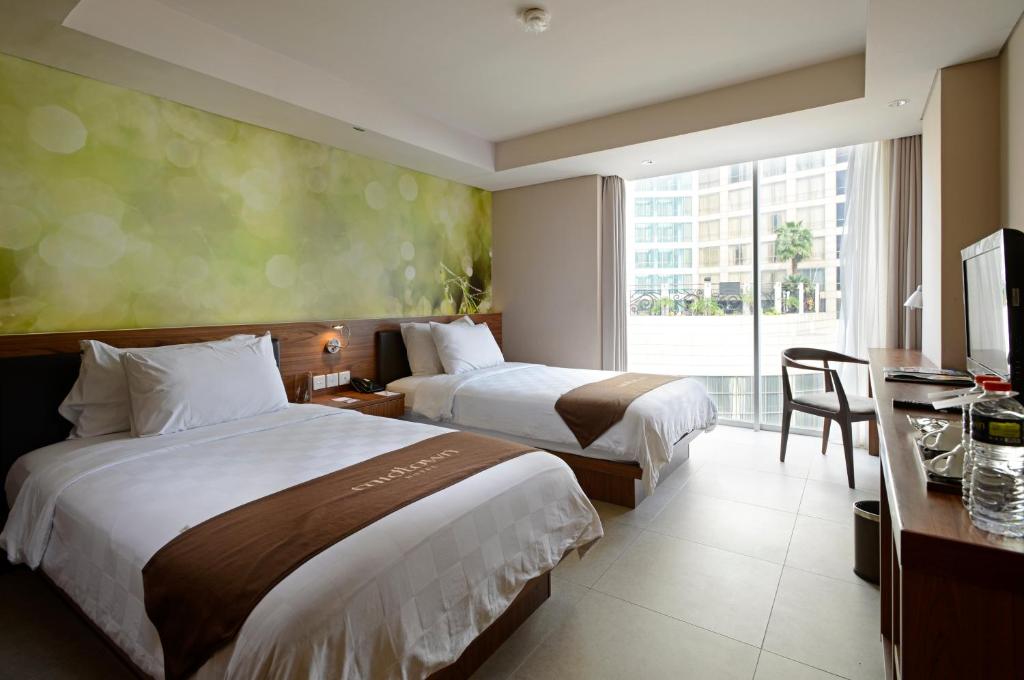 Postel nebo postele na pokoji v ubytování Midtown Hotel Surabaya
