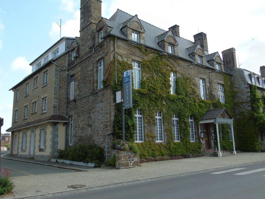 un gran edificio de ladrillo con hiedra creciendo en él en Best Western Hôtel Montgomery en Pontorson