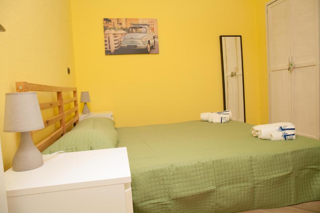 sypialnia z zielonym łóżkiem z lampką i lustrem w obiekcie casa margherita w mieście Borgo San Dalmazzo
