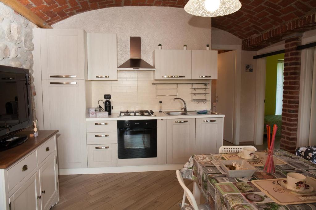 kuchnia z białymi szafkami i stołem z tabelą sidx sidx w obiekcie casa margherita w mieście Borgo San Dalmazzo