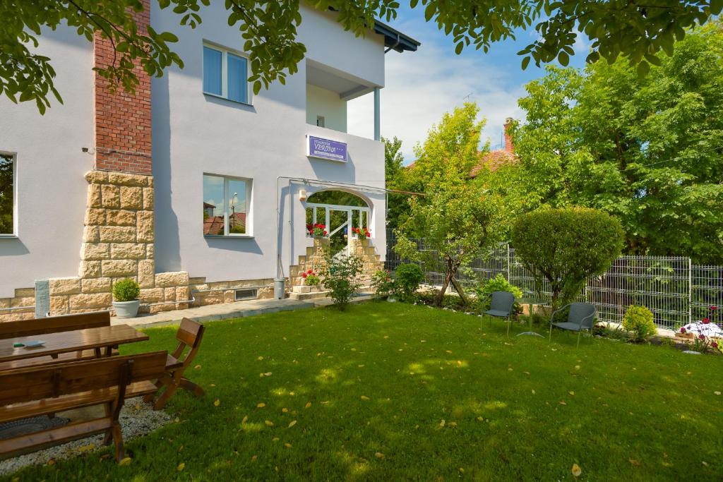 een tuin met een bankje voor een huis bij Pension Verona Centru in Cluj-Napoca