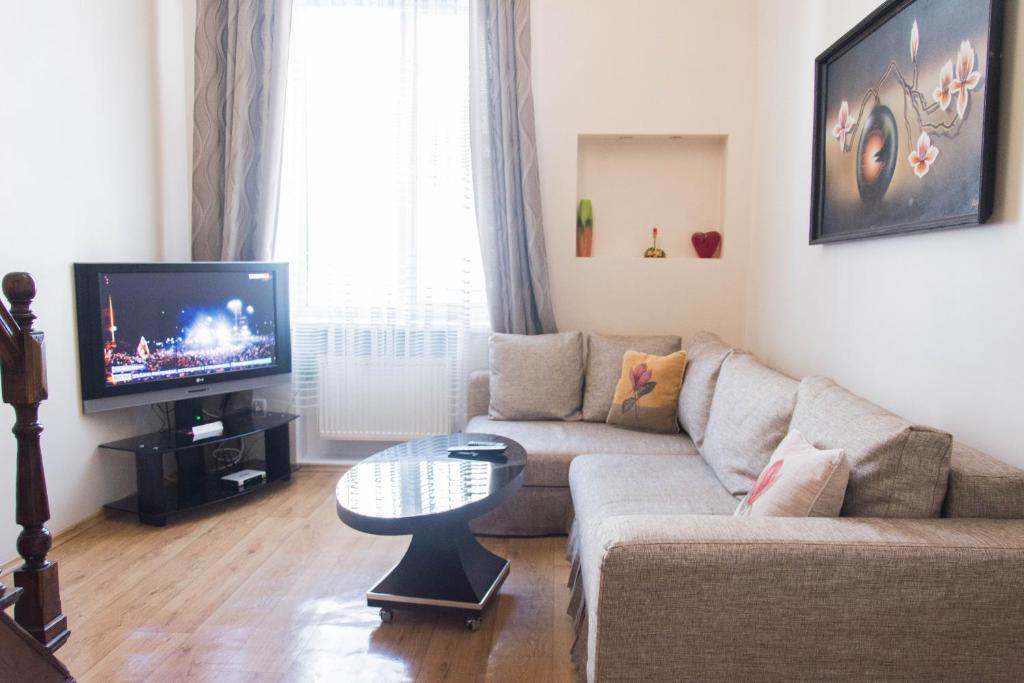 een woonkamer met een bank en een tv bij Deribasovskaya,16 in Odessa