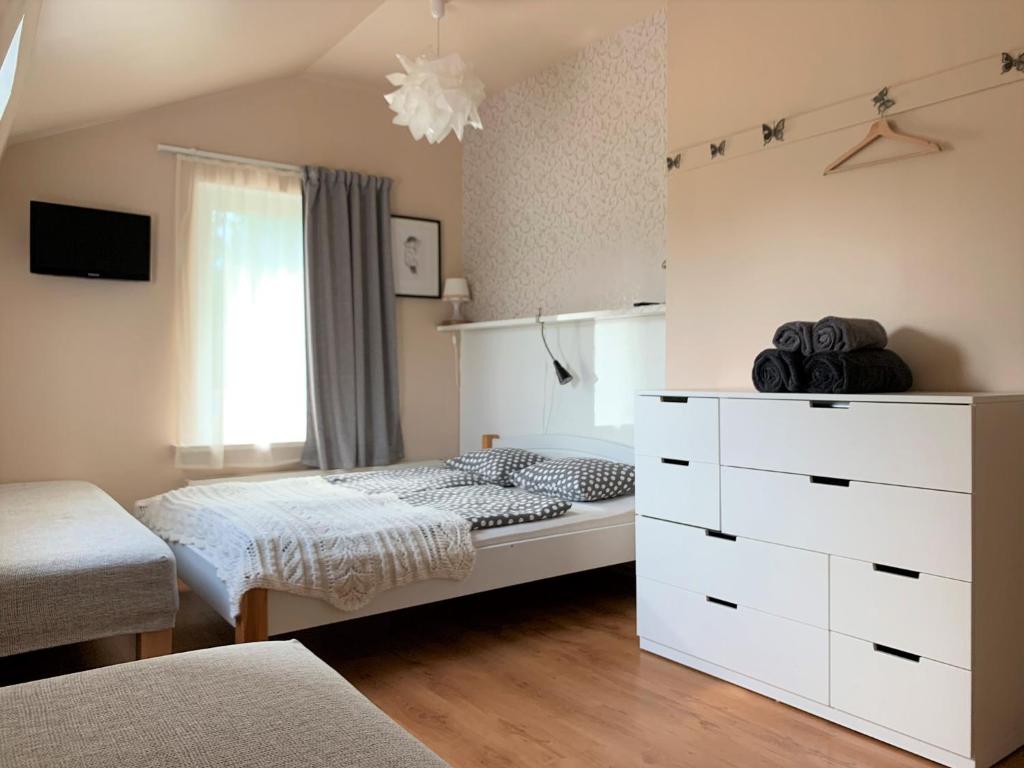 a bedroom with a bed and a white dresser at Beltes Guest House in Jūrmala
