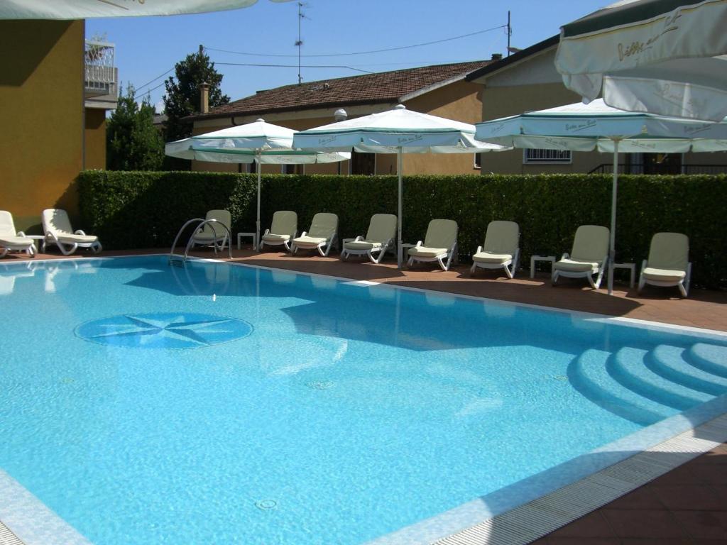 a large blue swimming pool with chairs and umbrellas at Albergo Ristorante Papa in Peschiera del Garda