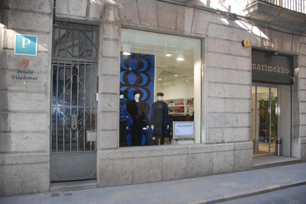 un front de magasin avec une fenêtre munie d'un panneau. dans l'établissement Pensió Viladomat, à Gérone